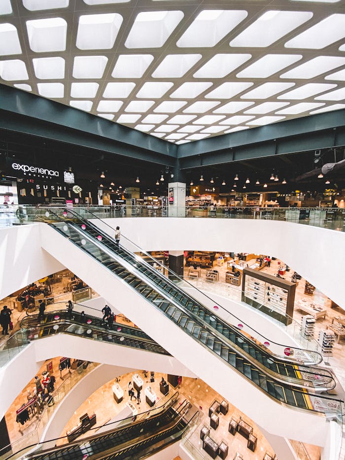 gallery-1 A bustling modern shopping mall with multiple escalators and retail shops in Toluca de Lerdo, Mexico.