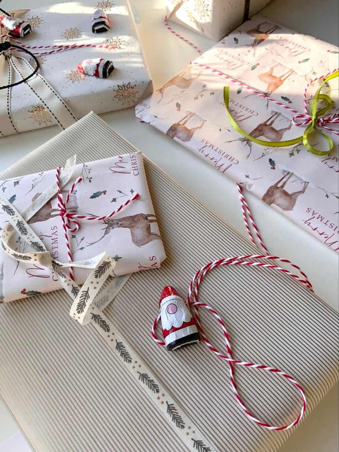 gallery-6 Elegant Christmas gift wrapping with festive ribbons and ornaments.