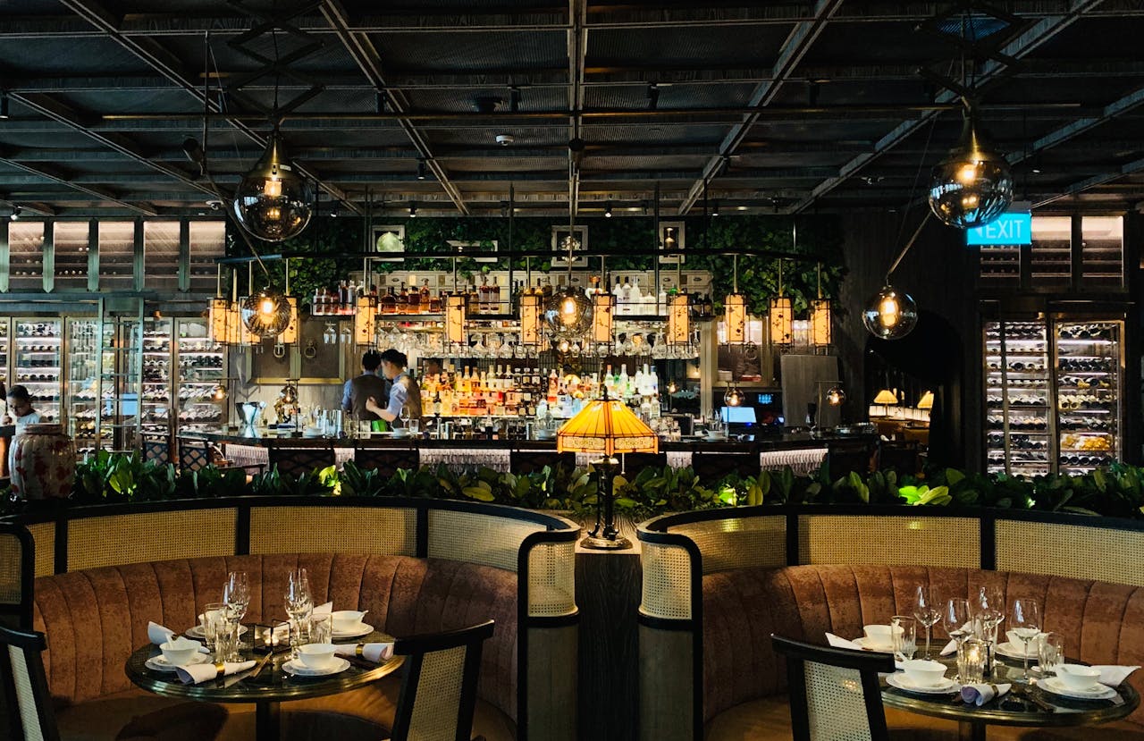 why-choose-us Cozy interior design of contemporary restaurant with round tables and soft couches against bar counter